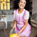 A woman cooking in a warm, inviting kitchen with rustic charm