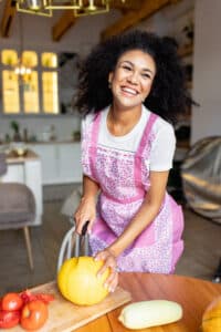 A woman cooking in a warm, inviting kitchen with rustic charm
